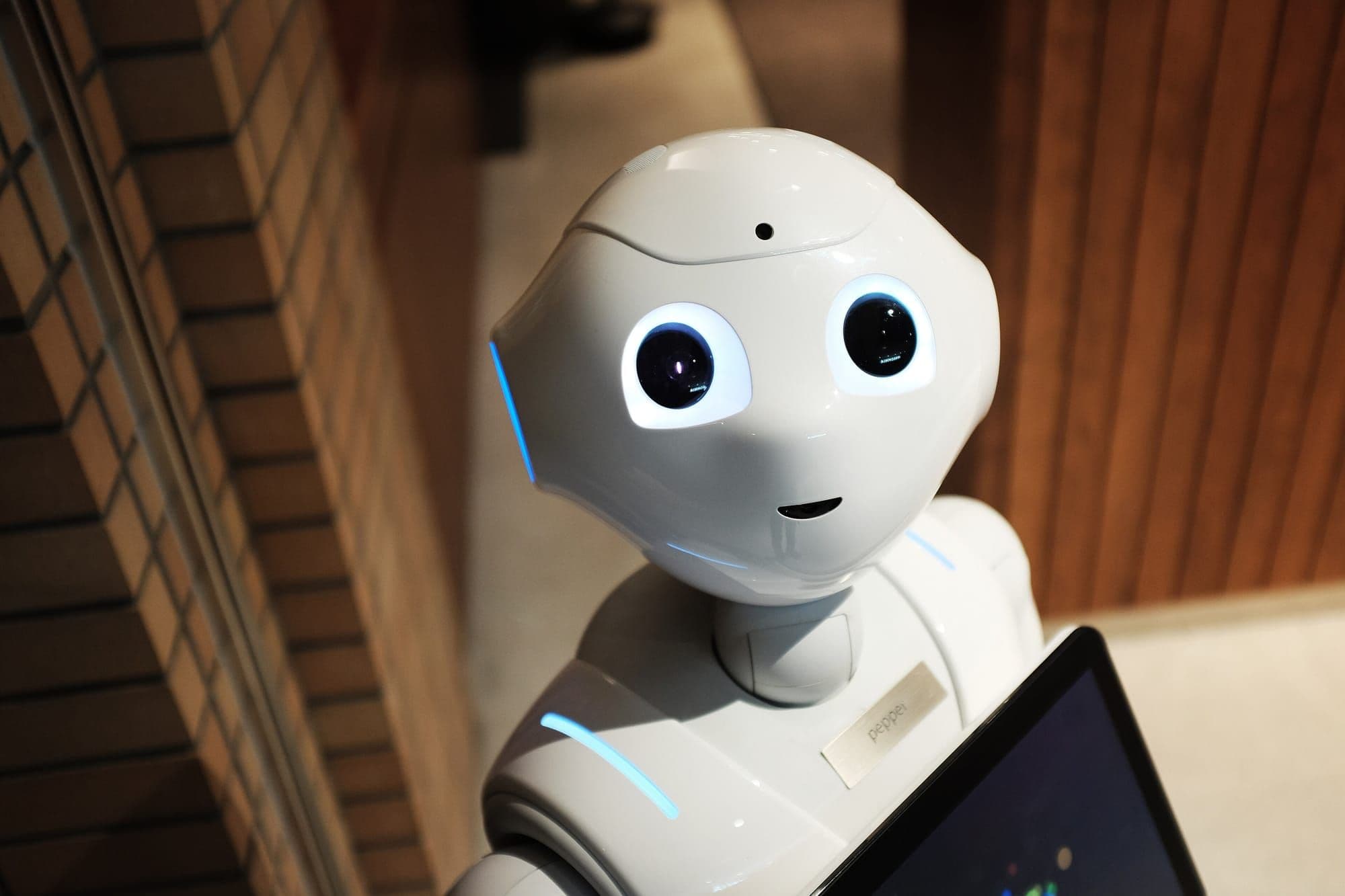 Friendly white humanoid robot holding a tablet